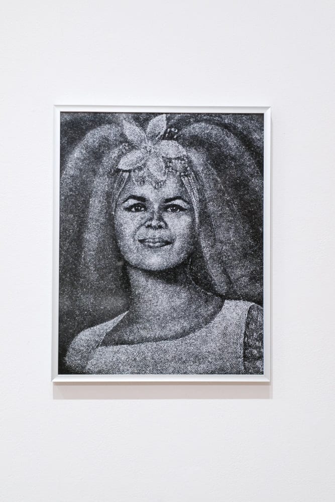Colour photo of a woman's portrait that has been laser-etched into black granite