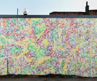 Image of a large graffiti mural entirely covering one wall of an urban building.