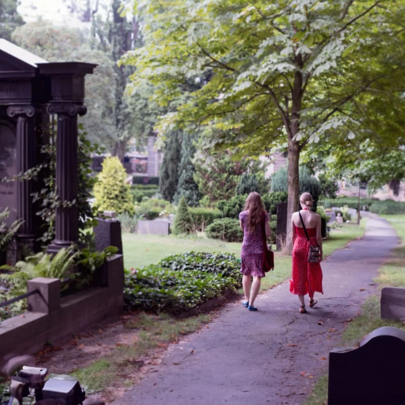 two women walking in a garden cemetery