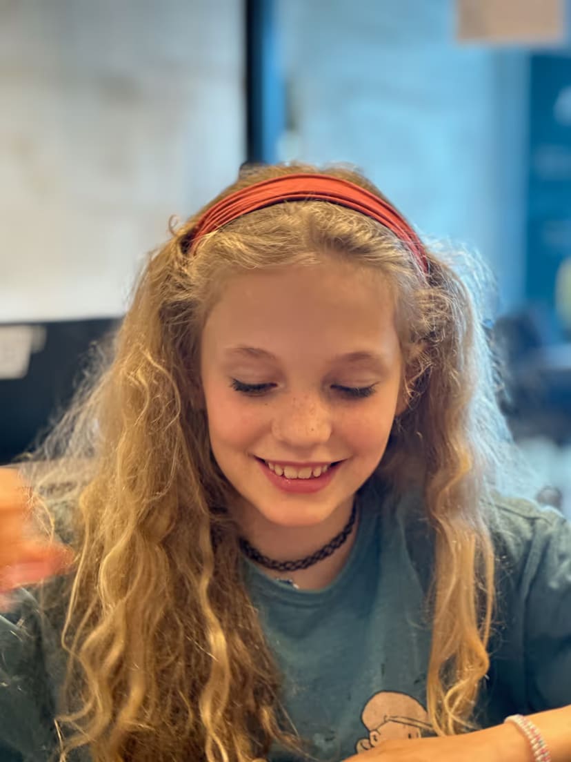 A student smiling as she works on her project.