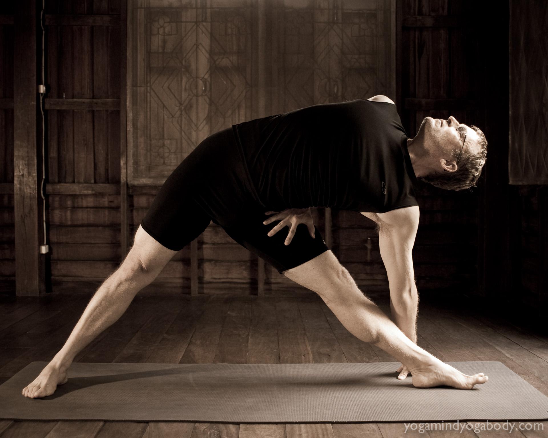 Gernot in Triangle Pose Gernot Huber practicing mindful yoga in Chiang Mai's Wild Rose Yoga Studio