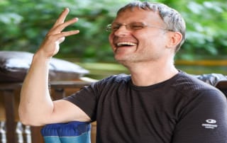 Gernot showing how to use a cushion for Nadi Shodhana pranayama.