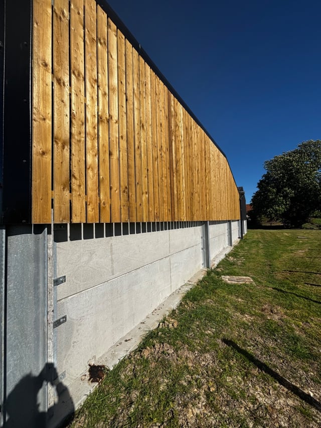 Weathered black timber cladding before preparation.