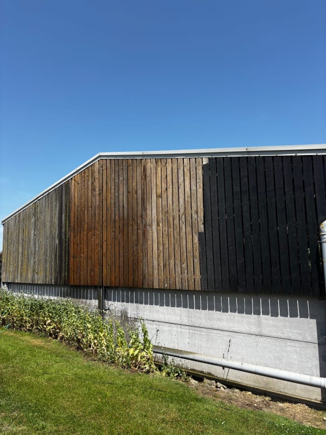 Coating application in progress on timber cladding.
