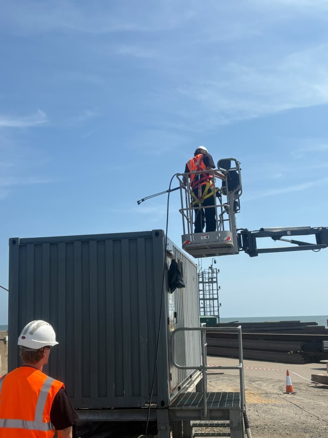 Coating application in progress on the container side.