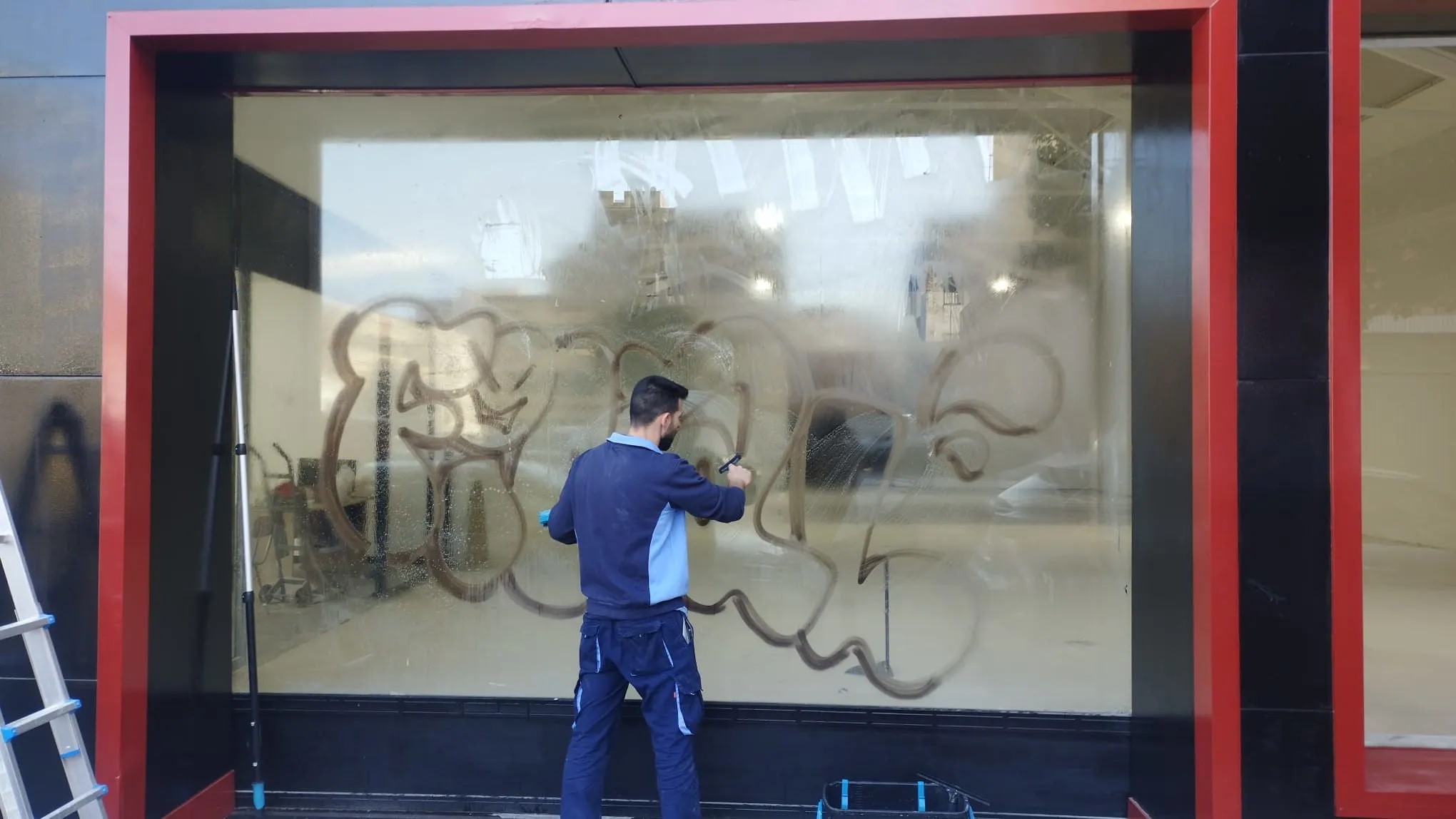 Eliminación de grafitis y pintura en el escaparate de un negocio