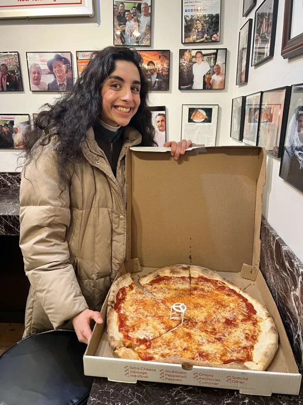 Deeva with a slice of New York style pizza from Joe's Pizza in New York City