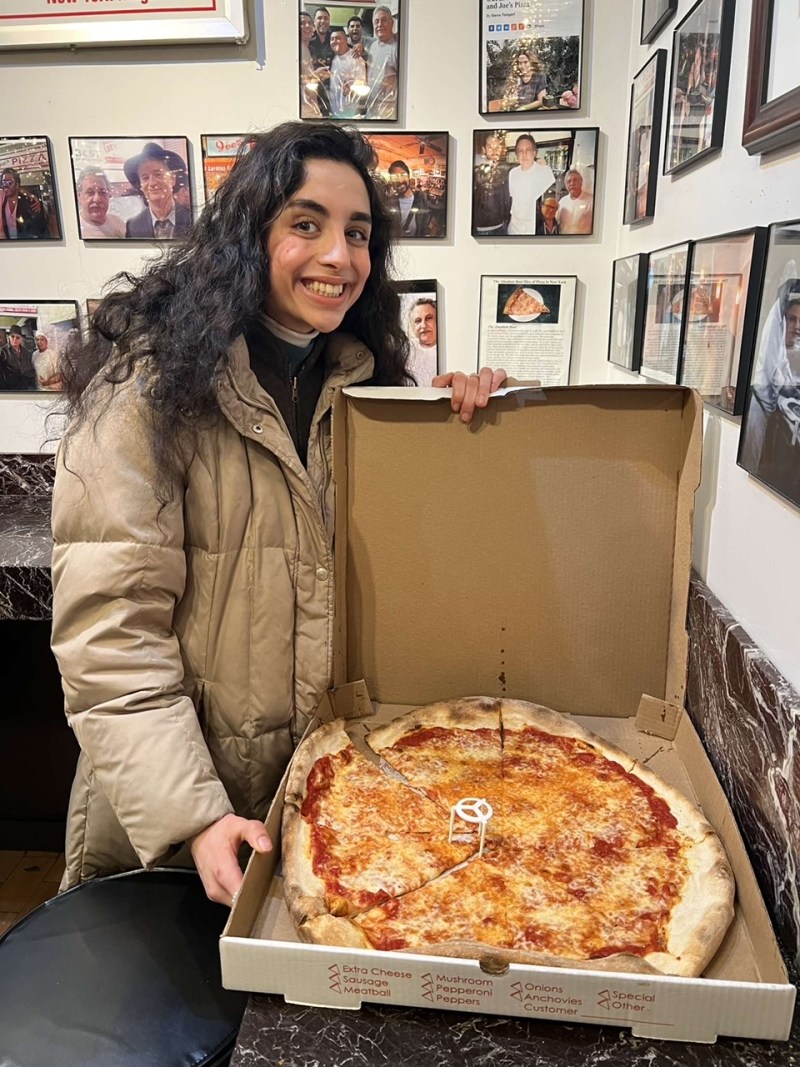 Deeva with a slice of New York style pizza from Joe's Pizza in New York City