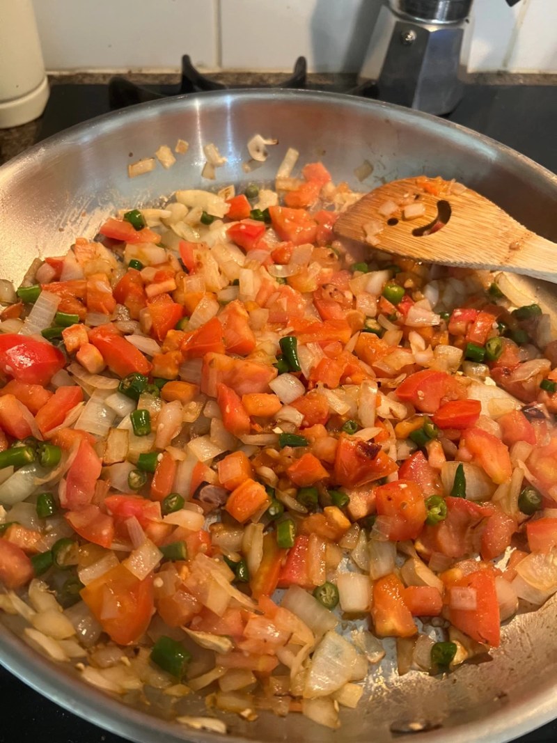 vegetbales cooking in a pan for desi eggs