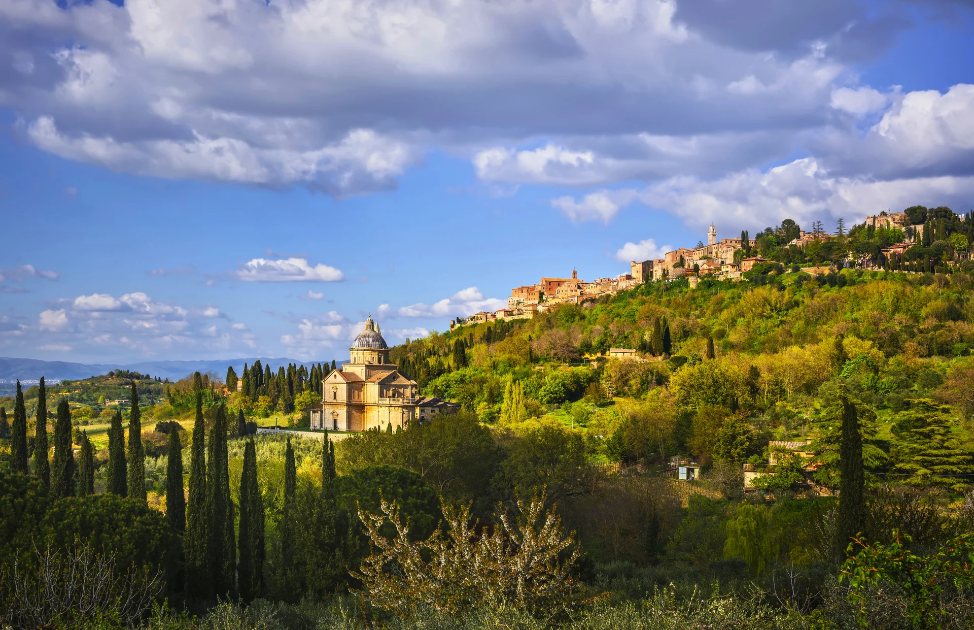 Kirche San Biagio und das mittelalterliche Dorf Montepulciano in der toskanischen Hügellandschaft.