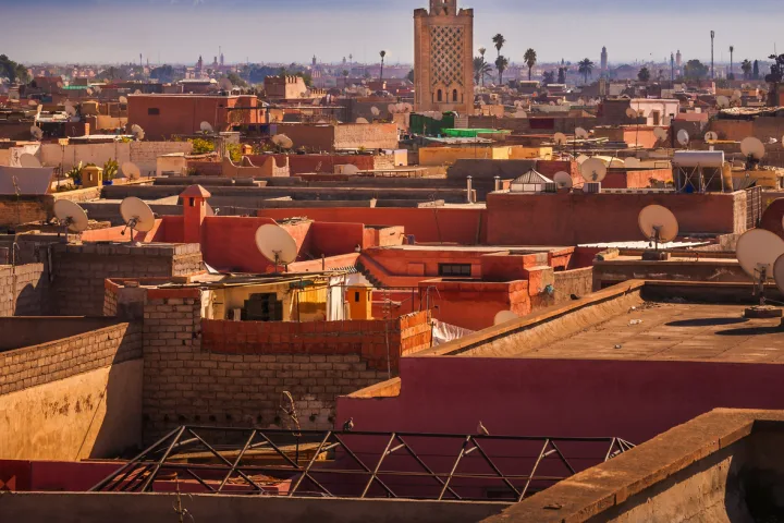 Panorama von Marrakesch mit Blick über die Dächer der Stadt, im Hintergrund das Atlasgebirge.