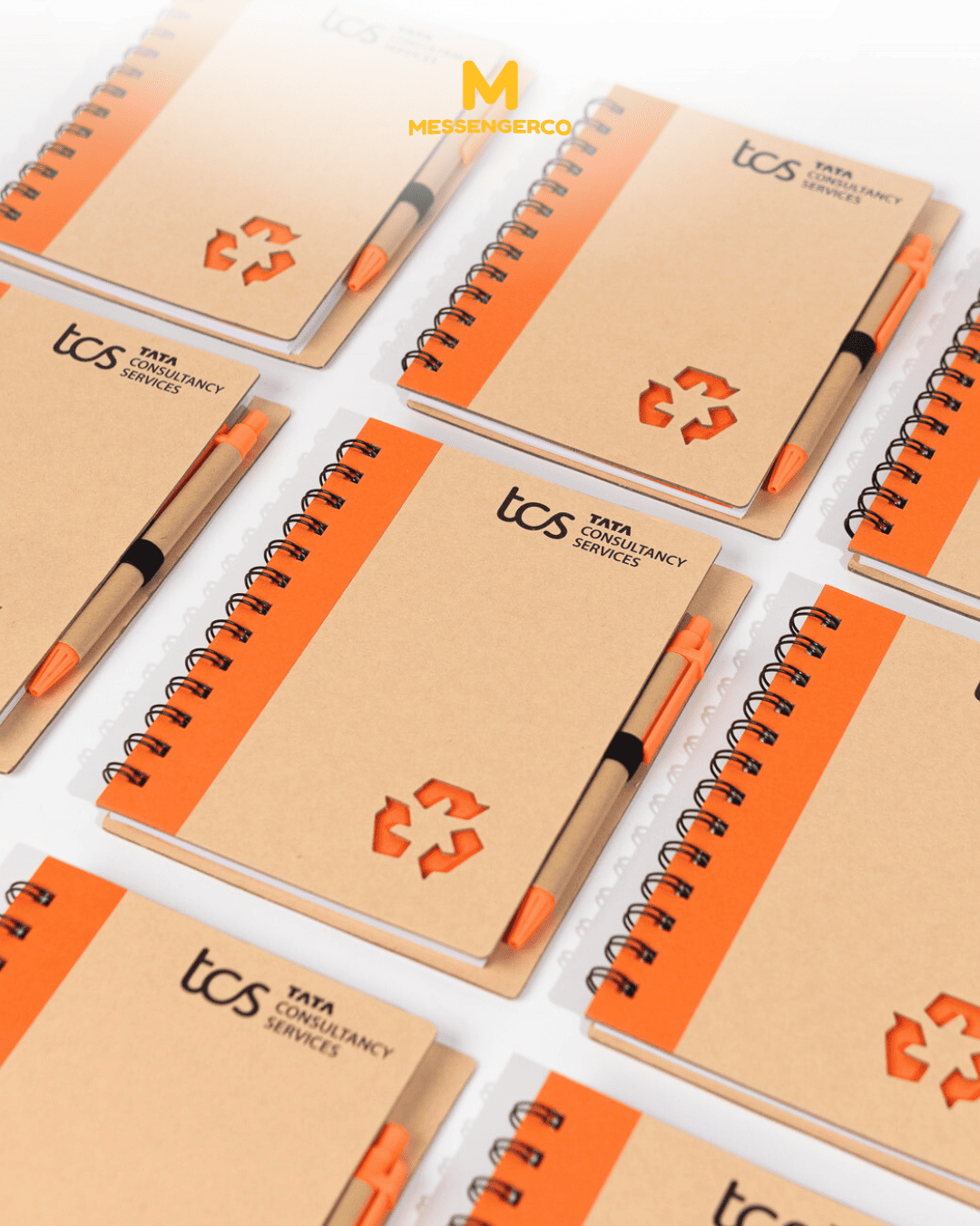 Eco-friendly orange and brown notebooks, each paired with a pen, both featuring logo printing, ideal for corporate gifting or promotional use.