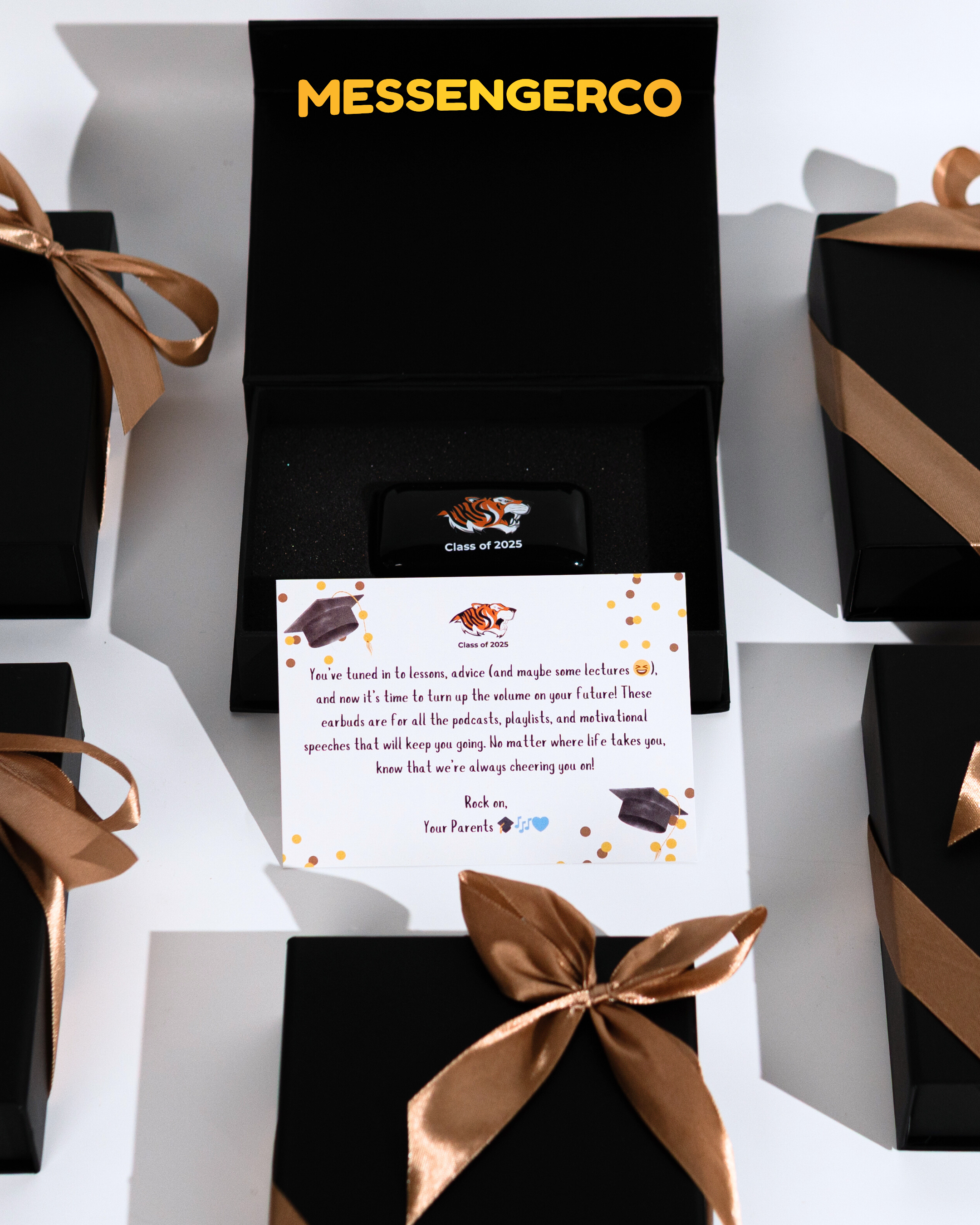 open matte black hard cover box with gold ribbon, personalised graduation card, and wireless earbuds inside for appreciation gift