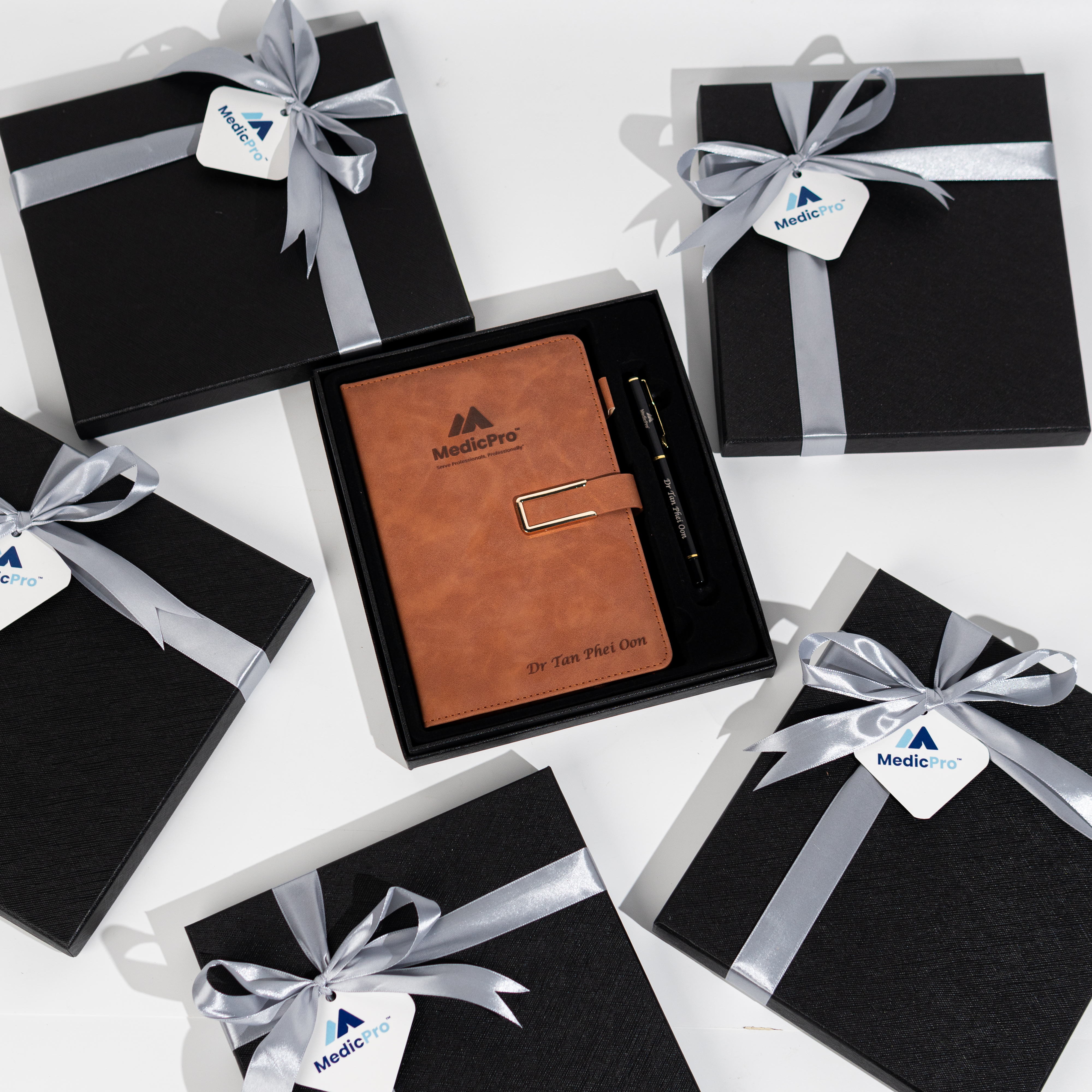 grey and brown notebook gift sets for medicpro arranged with elegant black packaging and silver bows