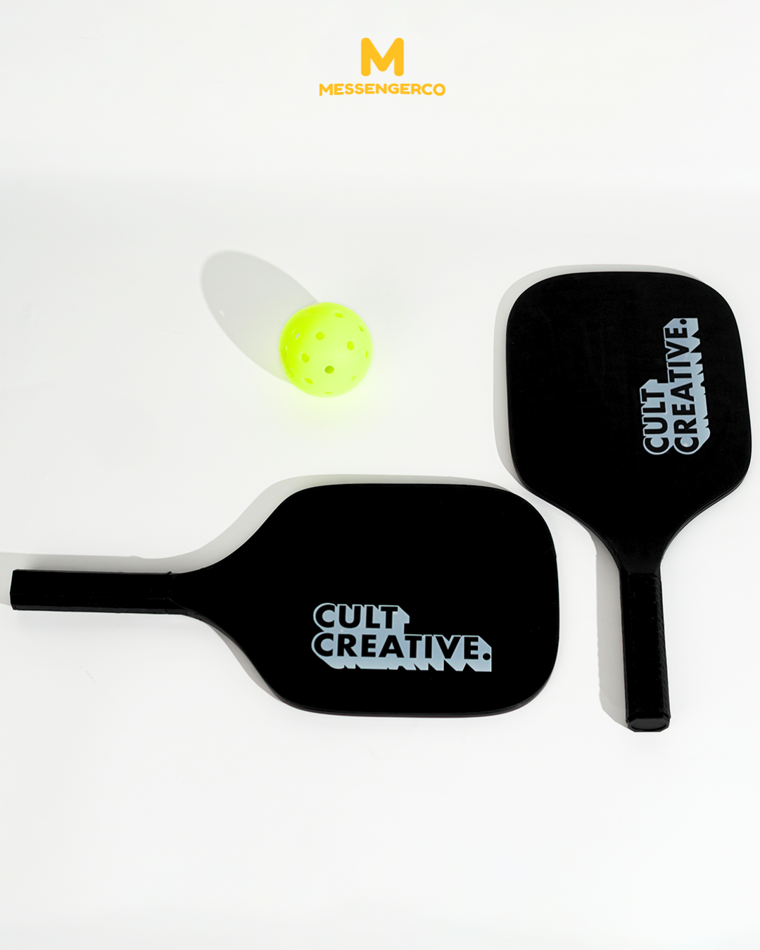 branded pickleball paddles with cult creative logo and ball arranged for team event set
