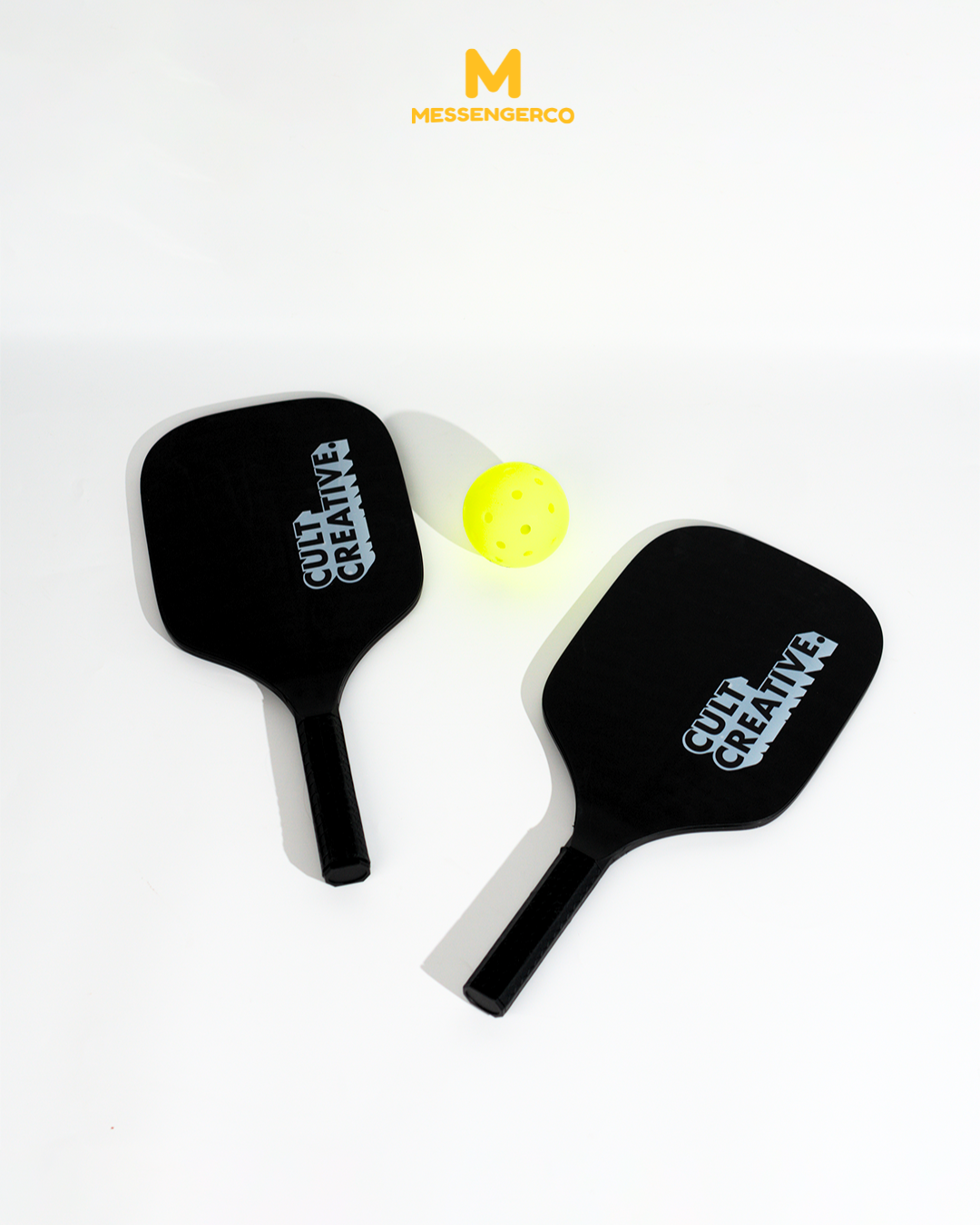 custom pickleball set for cult creative featuring branded paddles and neon yellow ball