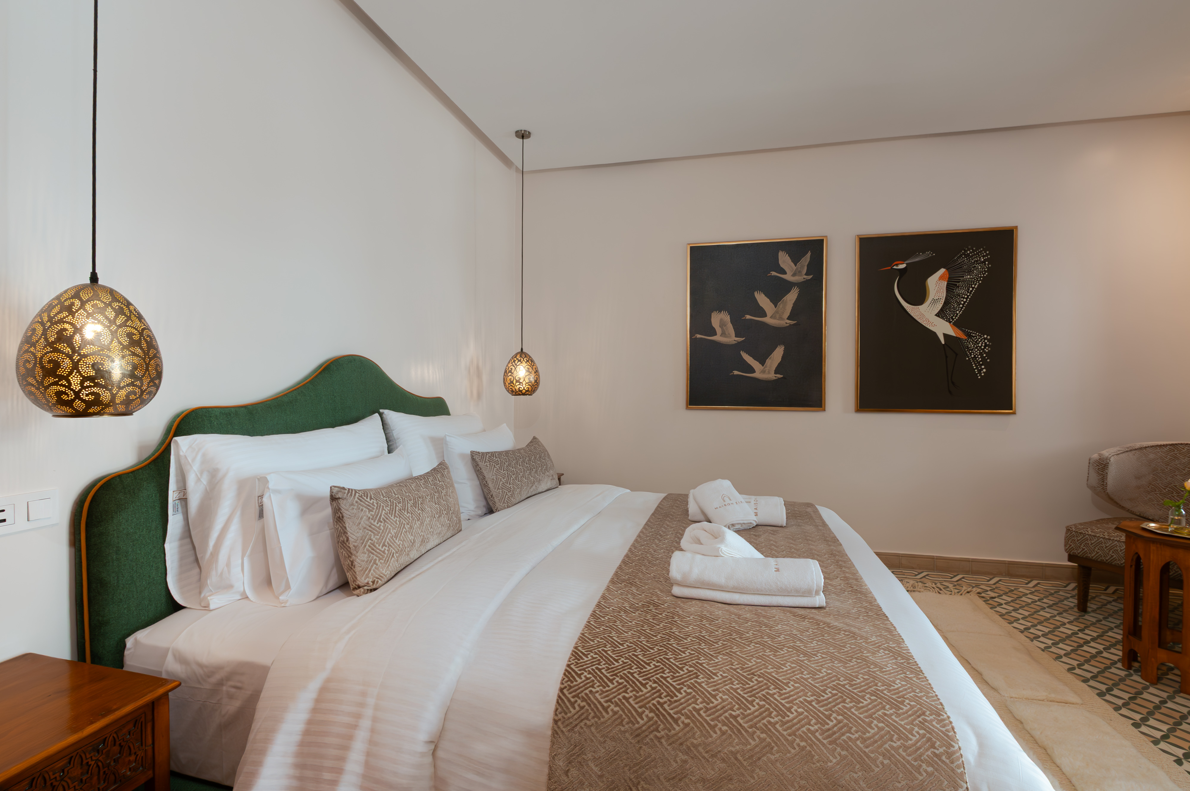 Bahja - Deluxe Room with sage green palette, crane paintings and velvet headboard