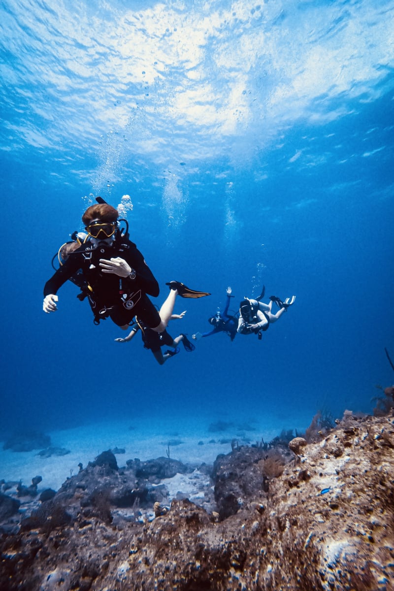 Divers explore a vibrant coral reef in crystalline turquoise waters