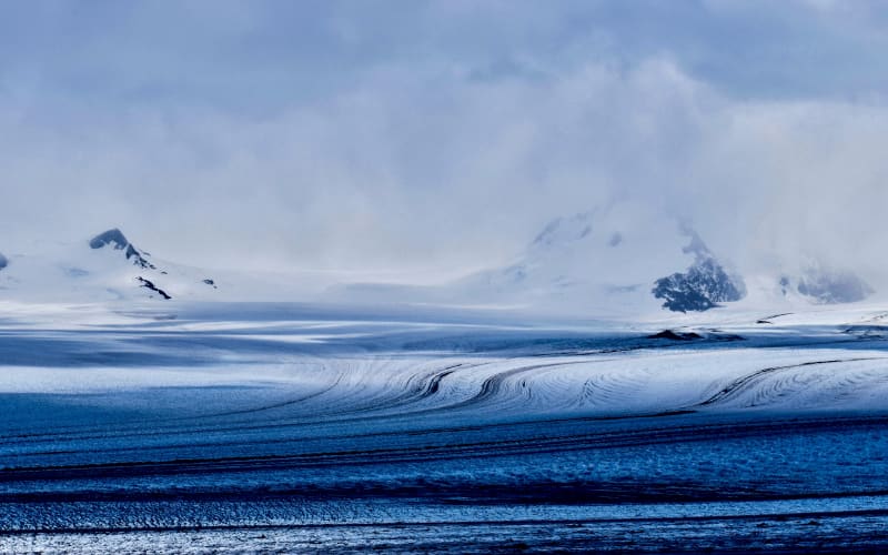 A glacial ice field sweeps toward cloud-wrapped peaks in Chilean Patagonia