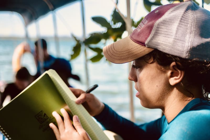 Student takes notes studying marine ecosystems along the Panama coast