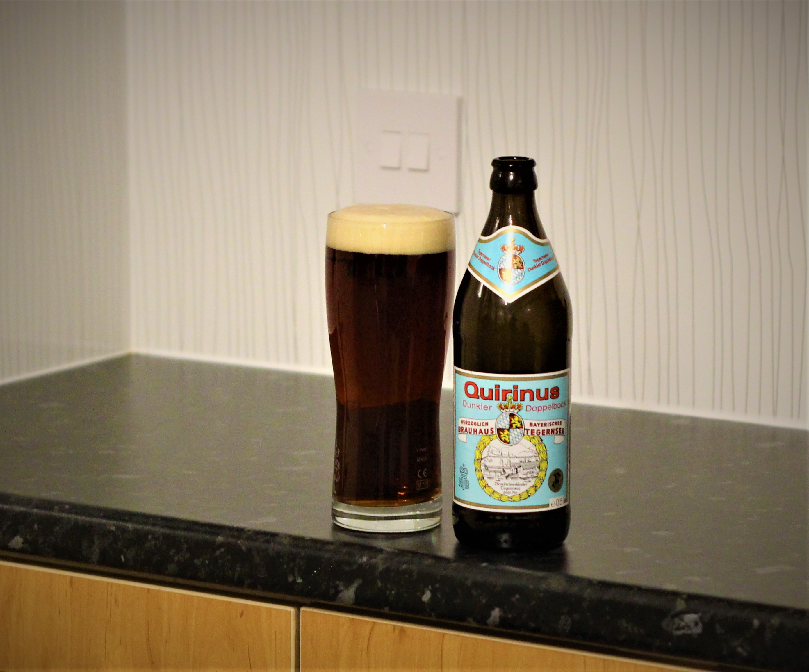 photo of tegernseer beer in glass next to bottle