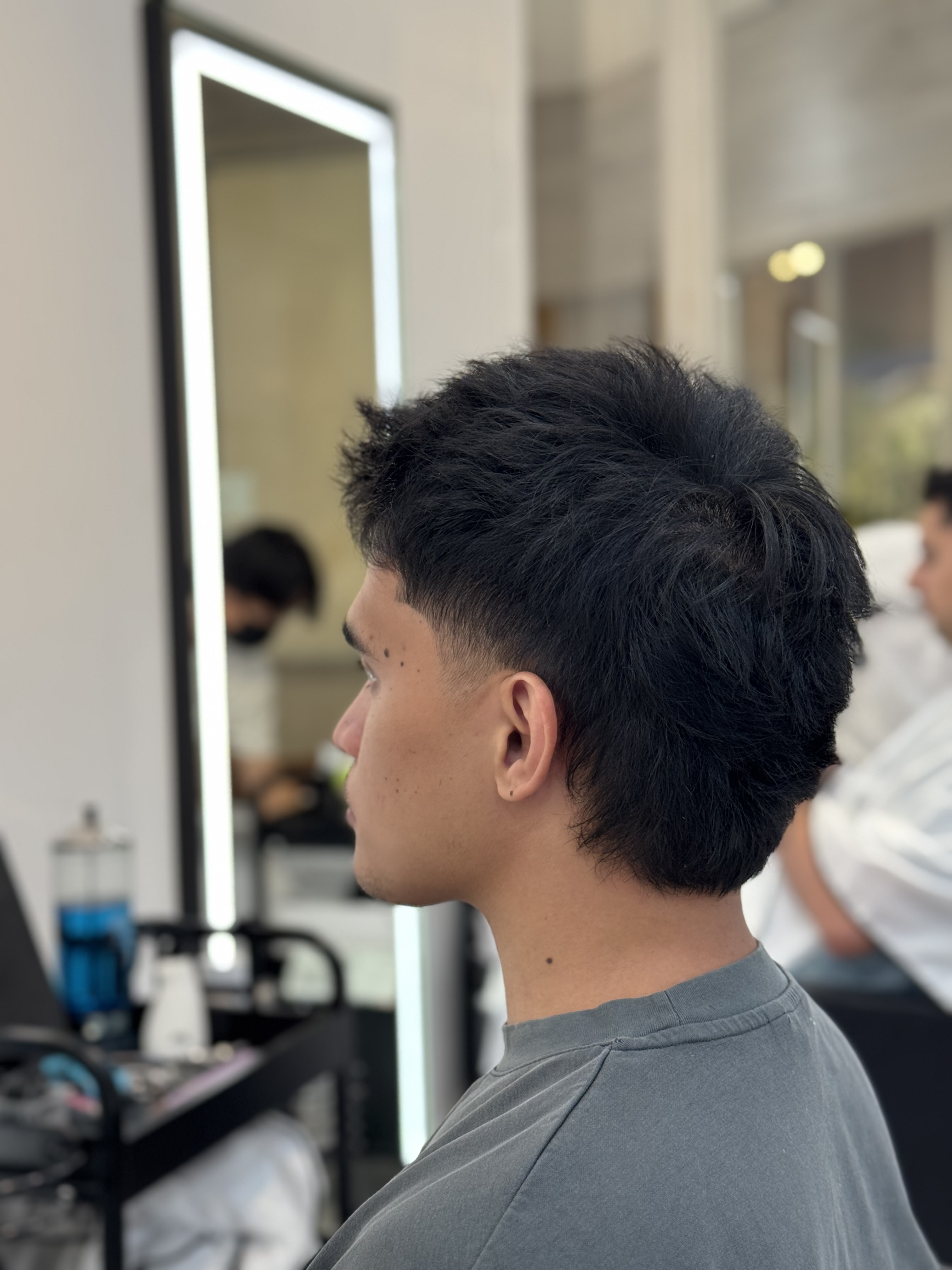 Side view of a textured mullet with a close temple taper and fuller hair through the back at B SIDE U Pasadena.