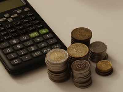 Egyptian Coins and Scientific Calculator on White Surface