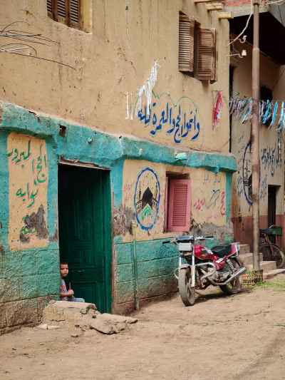 A Child Peeking Through an Old Door in Gerees Village, Egypt