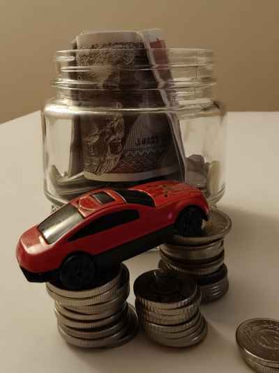 Small Car With Coins and Cash Jar, Car Financing Concept