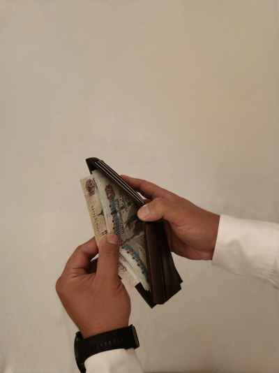 Hands Holding Wallet with Egyptian Pound Banknotes