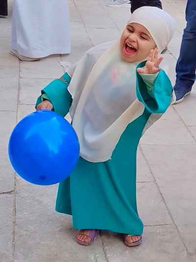 Laughing Little Girl in Green Eid Outfit