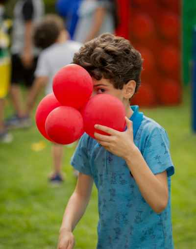 Young Boy Holding Red Balloons Outdoors, Cairo