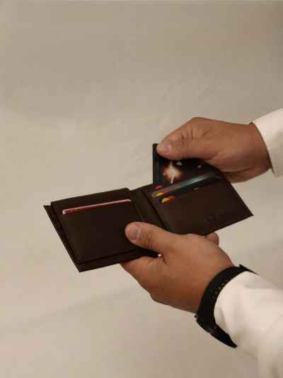 Man Holding Open Brown Leather Wallet with Cards