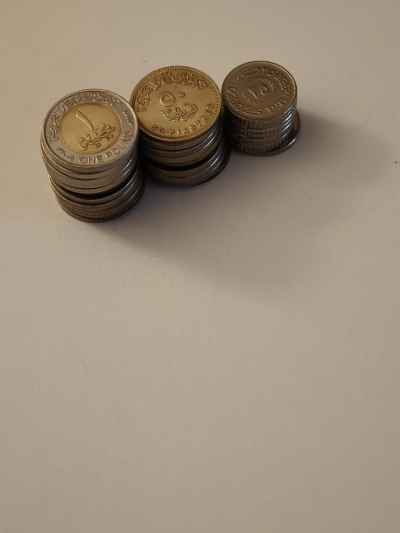 Egyptian Pound Coins Stacked on White Surface