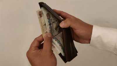 Man Holding Wallet with Egyptian Pound Banknotes