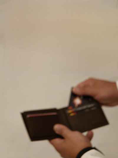 Hand Pulling Credit Card From Brown Leather Wallet