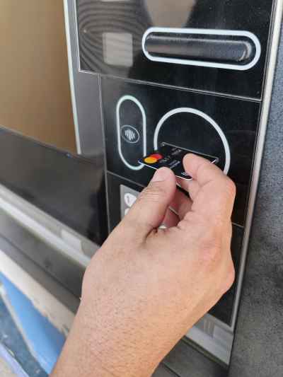 Hand Inserting Mastercard Debit Card Into ATM