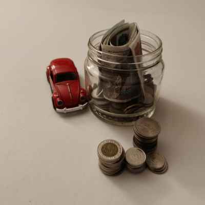 Egyptian Banknotes and Coins in Jar with Red VW Car