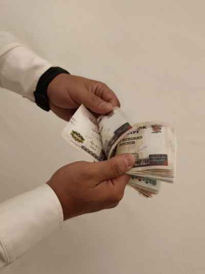 Egyptian Pound Banknotes Held in Hands