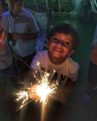 Smiling Egyptian Child Holding a Sparkler at Night