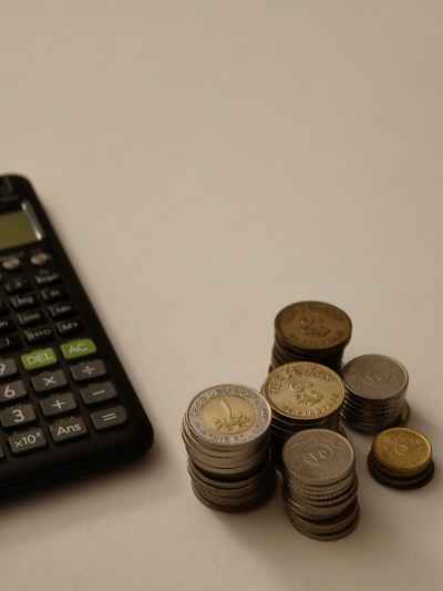 Egyptian Coins Stacked Beside Scientific Calculator