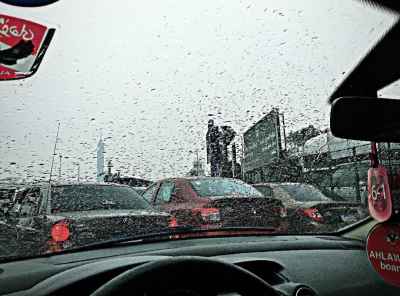 Raindrops on Car Windshield in Giza Street Traffic