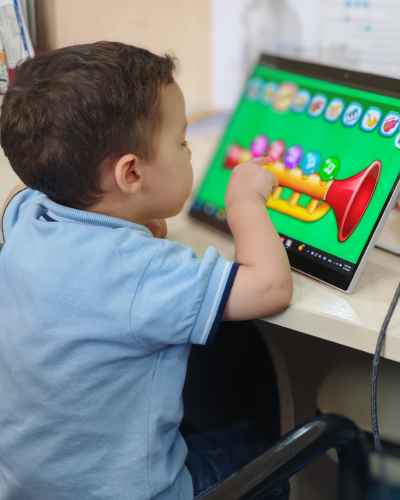 Child Interacting with Musical Educational App on Tablet