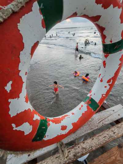 Children Swimming at Ras El Bar Beach Through Life Ring