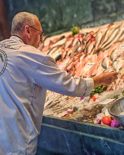 Seafood Expert Inspecting Fresh Fish Display, Cairo