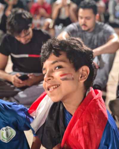 Young Egyptian Fan with Flag Face Paint at Match