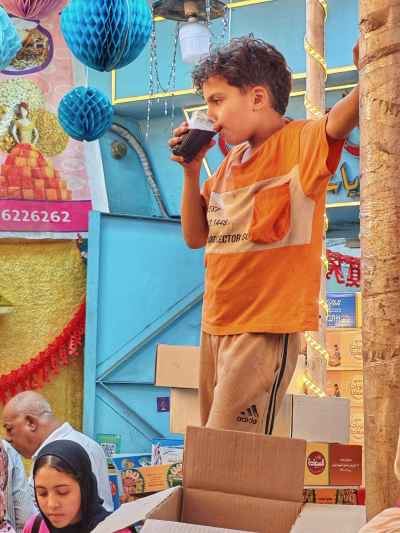 Child Drinking Juice at Moulid Tent, Bein El-Haraat Cairo