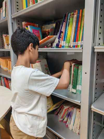 Child Selecting Book from Library Shelf, Cairo