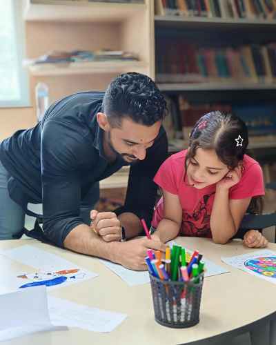 Instructor Helping Girl Drawing Activity, Children's Library Cairo