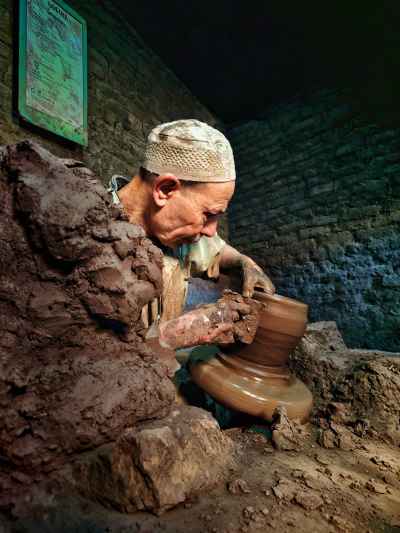 Potter Shaping Clay on Wheel, Gharees Village, Al-Monofeya